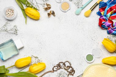 Şık kadın aksesuarlarından, kozmetik ürünlerinden ve açık arkaplandaki çiçeklerden yapılmış çerçeve