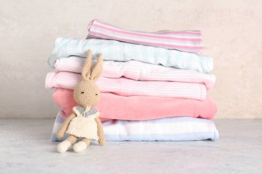 Hafif arka planda örülmüş oyuncak bebek kıyafetleri yığını