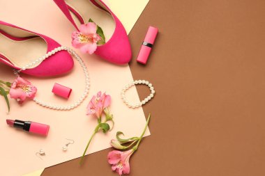 Renkli arkaplanda güzel kadın aksesuarları, topuklar, ruj ve alstroemeria çiçekleri olan kompozisyon