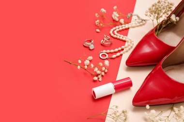 Şık kadın aksesuarları, ruj, topuklu ayakkabılar ve renk arka planında çigila çiçekleri olan kompozisyon