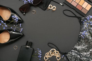 Siyah arka planda şık kadın aksesuarları, kozmetik ürünleri ve kıyafetlerinden yapılmış çerçeve, yakın plan