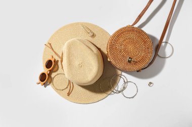 Beyaz arka planda güneş gözlüklü, çantalı ve yaz şapkalı mücevherler.