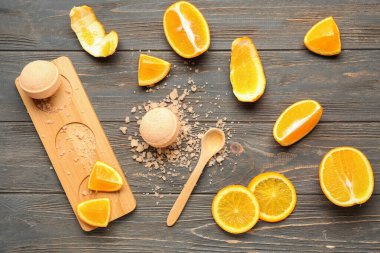 Portakal dilimli banyo bombaları ve ahşap zemin üzerinde deniz tuzu.