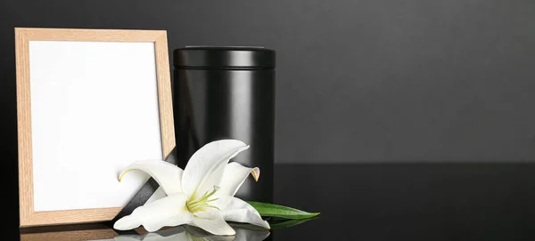 テキストのためのスペースを持つ暗い背景に葬儀用の骨壷 空白の写真フレームと白いユリの花 — ストック写真