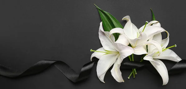 stock image Black funeral ribbon and white lily flowers on dark background