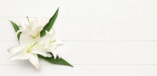 stock image Delicate lily flowers on white wooden background with space for text