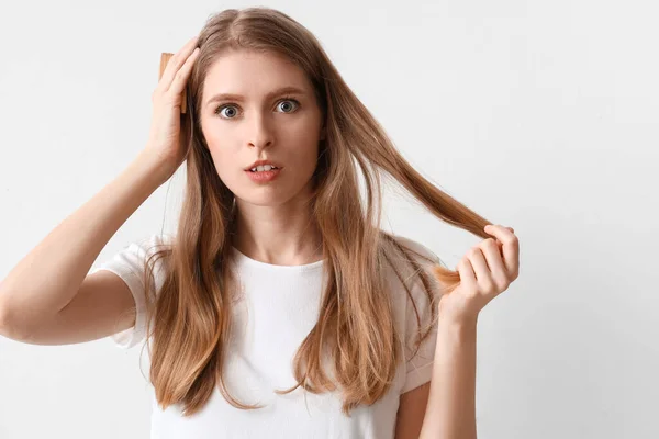 Šokovaná Mladá Žena Problémem Vypadávání Vlasů Hřeben Světlém Pozadí — Stock fotografie