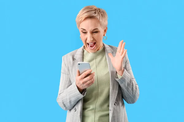 Açık Mavi Arka Planda Telefonu Olan Öfkeli Olgun Bir Kadın — Stok fotoğraf
