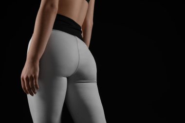 Siyah arka planda taytlı genç bir kadın.