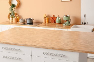 Şık bir mutfağın içinde çekmeceleri olan bir masa.