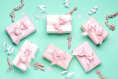 Fiyonklu hediye kutuları, türkuaz arka planda yılan ve konfeti.