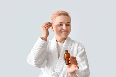 Bornozlu genç bir kadın ve arka planda serumu var.