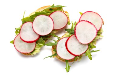 Beyaz arka planda turp ve roka ile nefis bruschetalar.