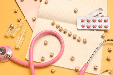 Sarı arka planda haplı, ampule, not defterli ve steteskoplu sözcükler.