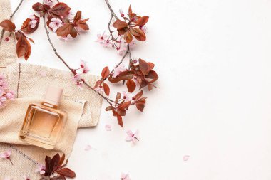 Çiçek açan güzel dallar ve arka planda bir şişe parfüm.