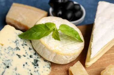 Masada farklı çeşit lezzetli peynirli ahşap tahta, yakın plan.