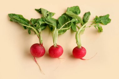 Sarı arka planda yaprakları olan taze turplar.