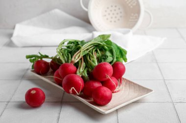 Açık fayanslı yapraklı taze turp tabağı