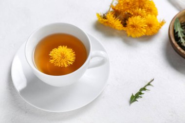 Beyaz arka planda bir fincan sağlıklı karahindiba çayı.