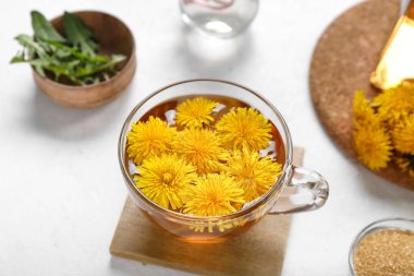 Beyaz arka planda bir bardak sağlıklı karahindiba çayı.