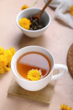 Bej arkaplanda bir fincan sağlıklı karahindiba çayı.