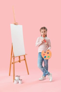 Pembe arka planda fırça ve palet çizimi olan düşünceli küçük bir kız. Çocuk Bayramı kutlaması