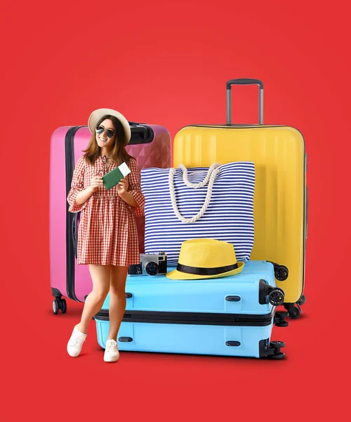 stock image Young female tourist with passport and big suitcases on red background