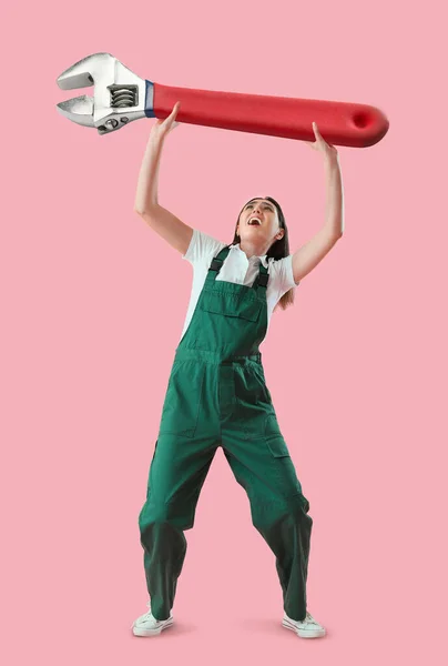 Besorgte Arbeiterin Mit Großem Schraubenschlüssel Auf Rosa Hintergrund — Stockfoto