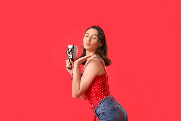 Mladý Pin Žena Retro Video Kamera Foukání Polibek Červeném Pozadí — Stock fotografie