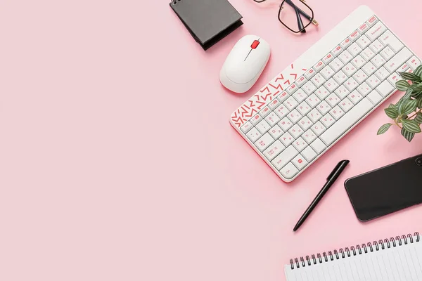 Composition with keyboard, mouse and mobile phone on pink background