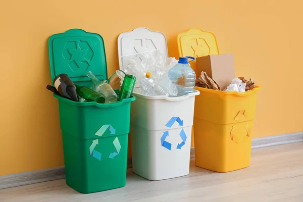 リサイクルシンボルと黄色の壁の近くに別のゴミとゴミ箱 — ストック写真