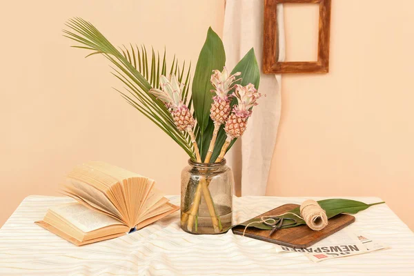 Wazon Dekoracyjnymi Ananasami Liśćmi Palmowymi Książką Liną Stole Przy Beżowej — Zdjęcie stockowe