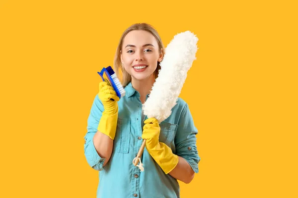 Jonge Vrouw Met Reinigingsborstel Stofdoek Gele Achtergrond — Stockfoto
