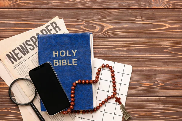 Holy Bible Prayer Beads Mobile Phone Magnifier Newspaper Notebook Wooden — Stock Photo, Image
