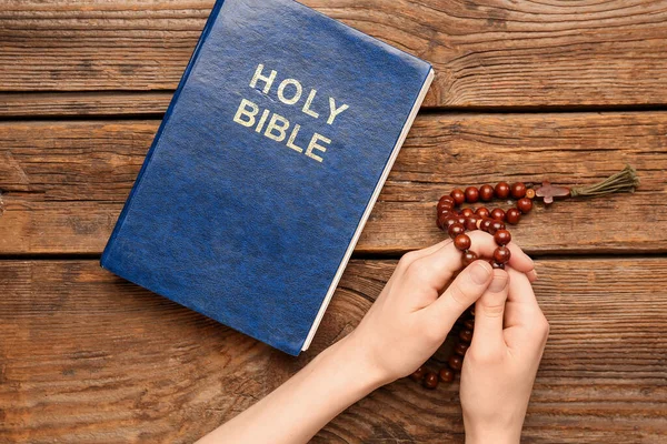 Kvinna Med Bönepärlor Och Bibeln Trä Bakgrund — Stockfoto