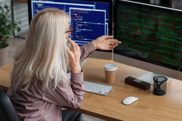 Gammal Kvinnlig Programmerare Talar Mobiltelefon Vid Bordet Kontoret — Stockfoto