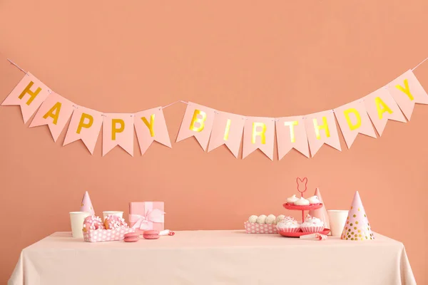 Słodycze Białym Stole Szczęśliwy Papier Urodzinowy Girlandy Ciemnym Beżowym Ścianie — Zdjęcie stockowe