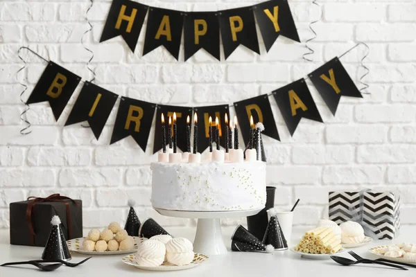 Tort Urodzinowy Świeczkami Białym Stole Girlandy Ceglanej Ścianie — Zdjęcie stockowe