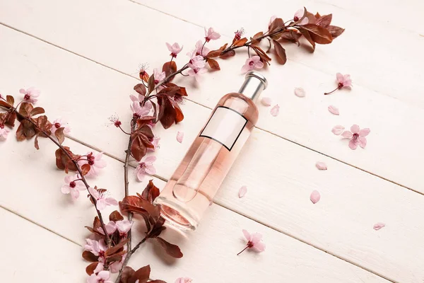 Piękne Kwitnące Gałęzie Butelka Perfum Jasnym Drewnianym Tle — Zdjęcie stockowe