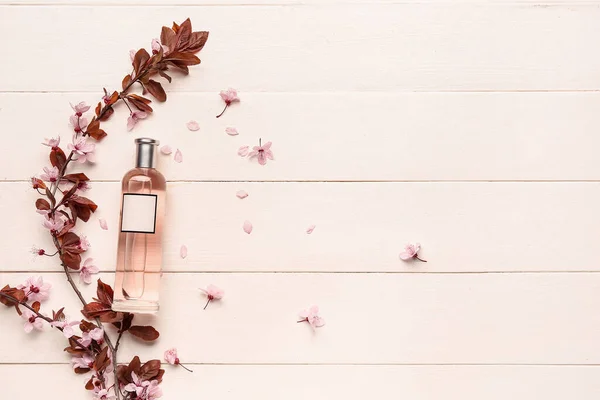 Schöne Blühende Zweige Und Eine Flasche Parfüm Auf Hellem Holzhintergrund — Stockfoto