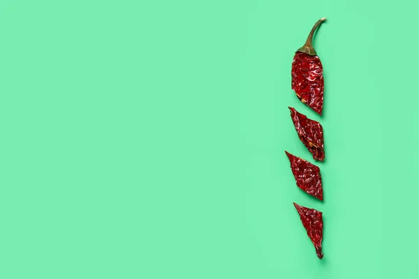 Cut chili pepper on green background