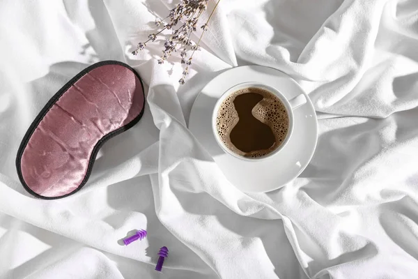 Schlafmaske Ohrstöpsel Und Tasse Kaffee Auf Dem Bett — Stockfoto