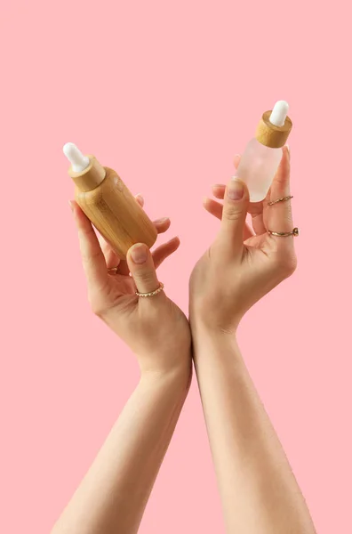 Pembe Arka Planda Kozmetik Ürünleri Tutan Eller — Stok fotoğraf