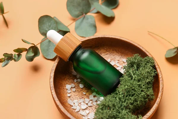 Wooden Plate Bottles Cosmetic Oil Eucalyptus Branch Orange Background — Stock Photo, Image