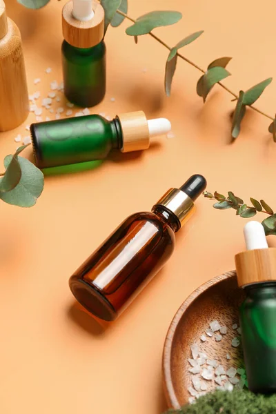 Wooden Plate Bottles Cosmetic Oil Eucalyptus Branch Orange Background — Stock Photo, Image