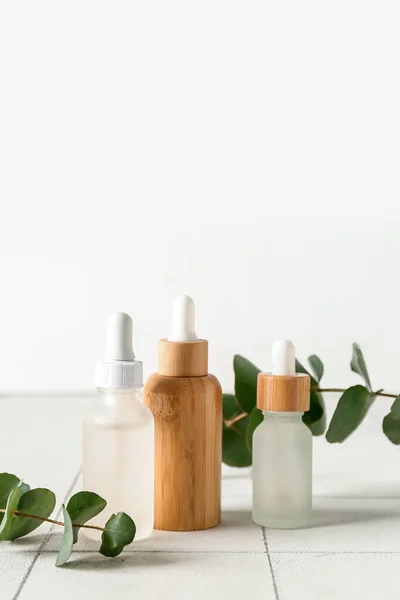 Bottles Cosmetic Oil Eucalyptus Branches White Tile — Stock Photo, Image