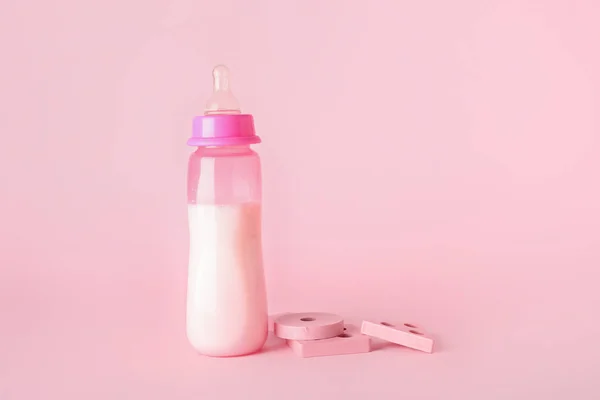 Botol Susu Untuk Bayi Dengan Mainan Latar Belakang Merah Muda — Stok Foto