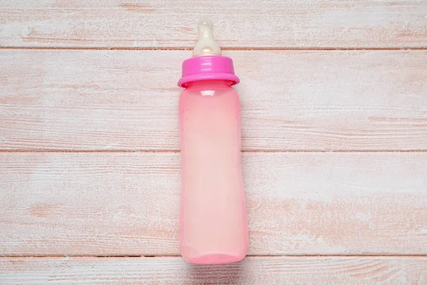 Botol Susu Untuk Bayi Dengan Latar Belakang Kayu Merah Muda — Stok Foto