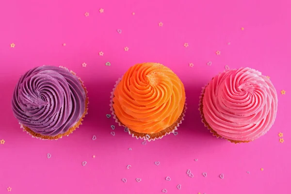 ピンクの背景においしいカラフルなカップケーキ — ストック写真