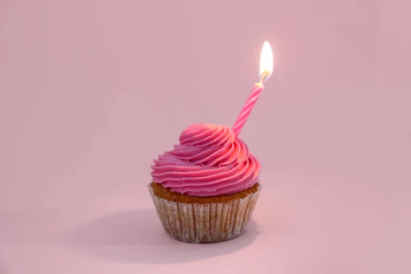 ピンクの背景に誕生日キャンドル付きおいしいカップケーキ — ストック写真